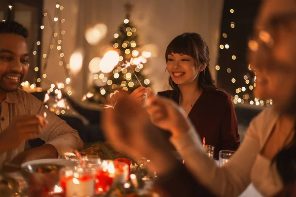 Ευτυχισμένοι φίλοι με βεγγαλικά στο Χριστουγεννιάτικο δείπνο — Φωτογραφία Αρχείου