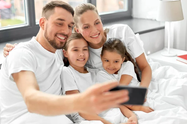 Rodzina z biorąc selfie w łóżku w domu — Zdjęcie stockowe