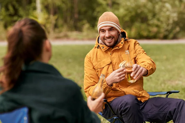 Couple drinking beer with sandwiches at tent camp — Stock Photo, Image