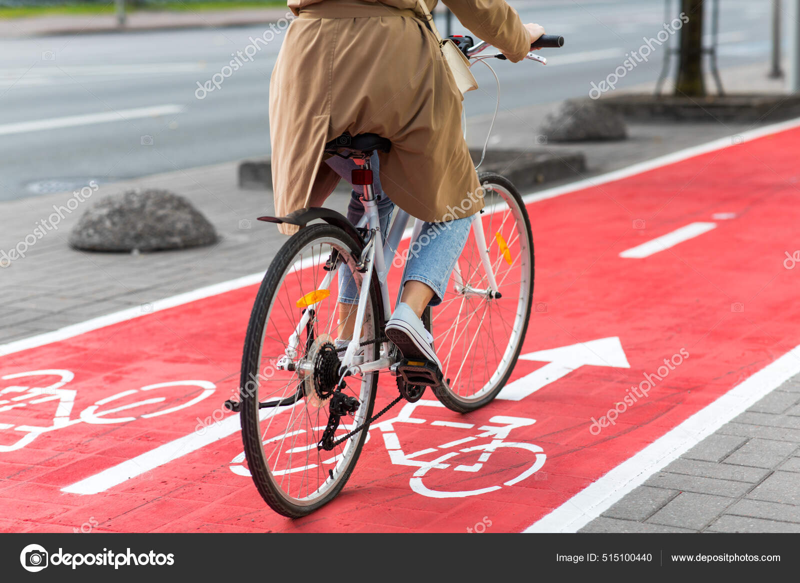 Ciclismo mujer a lo largo de carril bici rojo carretera en la