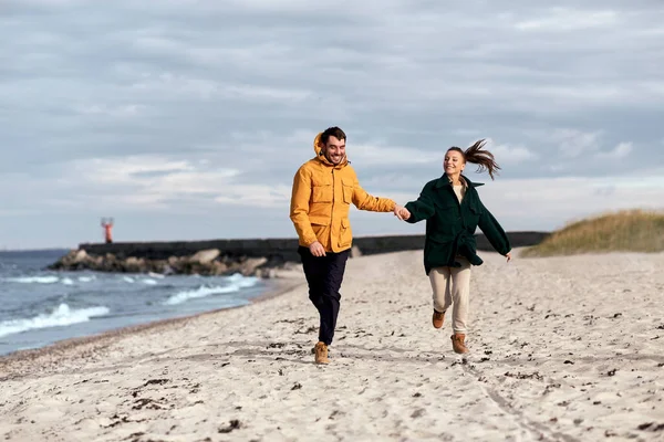 Casal correndo ao longo da praia de outono — Fotografia de Stock