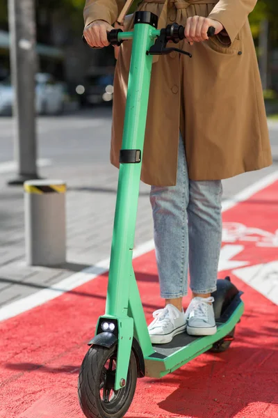 Mujer montando scooter a lo largo de carril bici carretera en la ciudad —  Fotos de Stock