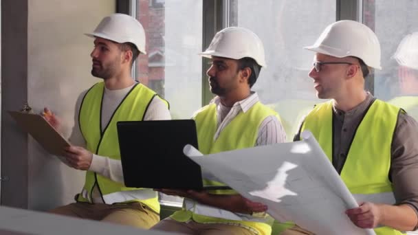 Мужчины-архитекторы в шлемах с ноутбуком в офисе — стоковое видео