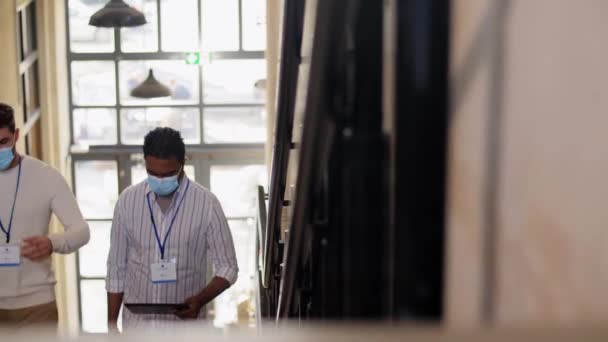 Uomini d'affari mascherati con cartellini che salgono al piano di sopra — Video Stock