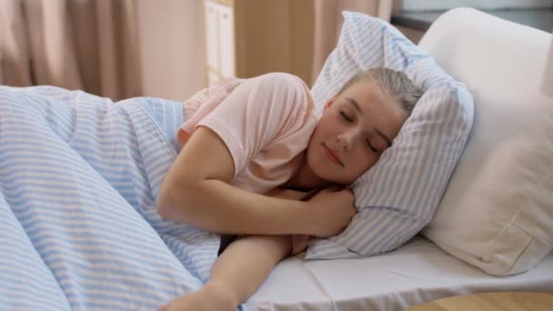 Schläfriges Mädchen wacht auf und dehnt sich zu Hause im Bett — Stockvideo