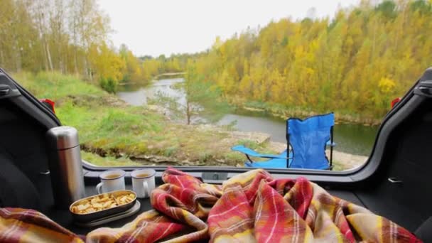 Vue sur la rivière depuis le coffre de la voiture avec couverture et thé — Video