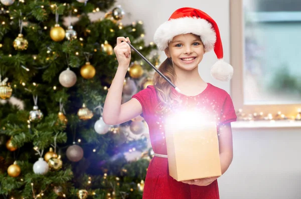 Menina sorridente com varinha mágica e presente de Natal — Fotografia de Stock