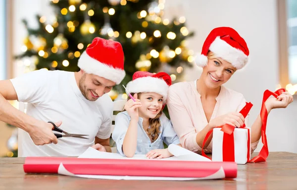 Familie met inpakpapier en kerstcadeau — Stockfoto