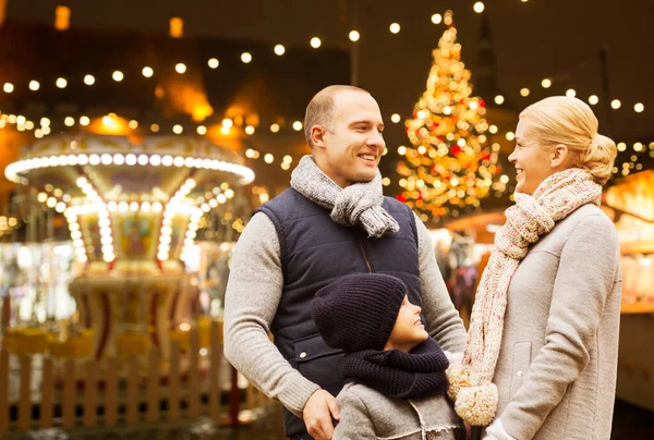 Familia feliz en el mercado de Navidad o parque de atracciones —  Fotos de Stock