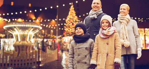 Счастливая семья на рождественском рынке или в парке развлечений — стоковое фото