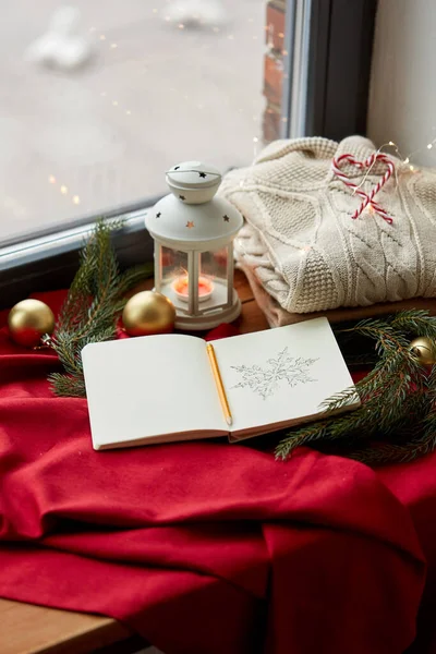 Schetsboek, kerstlantaarn, trui, dennentak — Stockfoto