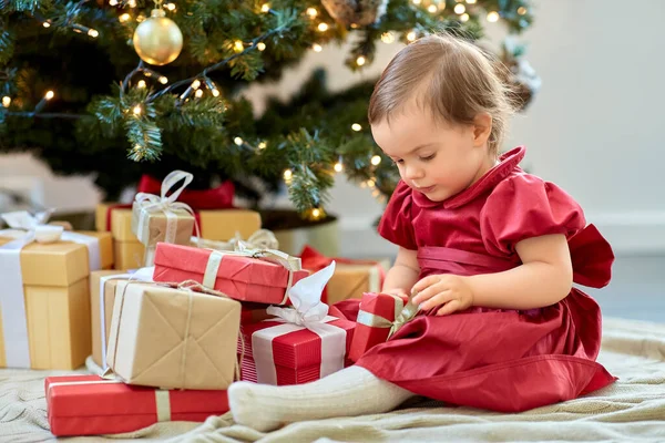 Happy baby girl opening christmas gifts at home — Stock Photo, Image