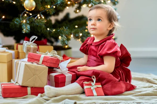 Счастливая девочка открывает подарки дома — стоковое фото