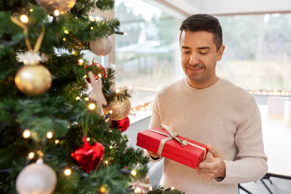 Glad medelålders man med julklapp hemma — Stockfoto