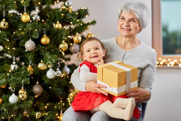 Oma en baby meisje met kerstcadeau — Stockfoto