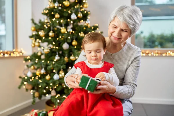 Großmutter und kleines Mädchen mit Weihnachtsgeschenk — Stockfoto