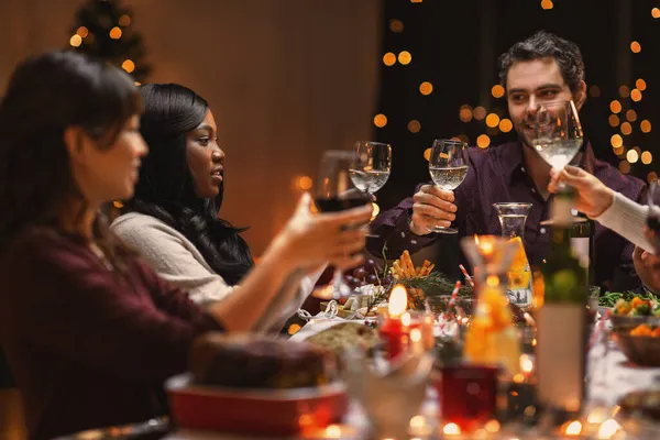 Amigos felices bebiendo vino en la fiesta de Navidad — Foto de Stock