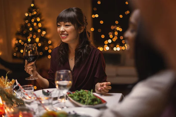 Счастливая женщина пьет красное вино на рождественской вечеринке — стоковое фото