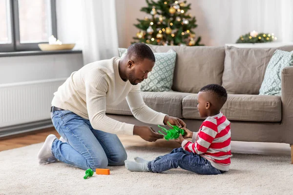 Glücklicher Vater, der an Weihnachten zu Hause mit Sohn spielt — Stockfoto
