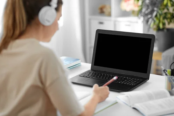 Student woman in headphones with laptop and book — Stock Photo, Image