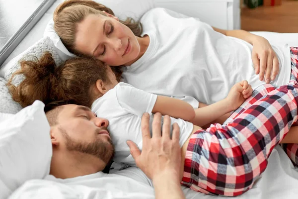 Feliz familia durmiendo en la cama en la mañana de Navidad —  Fotos de Stock