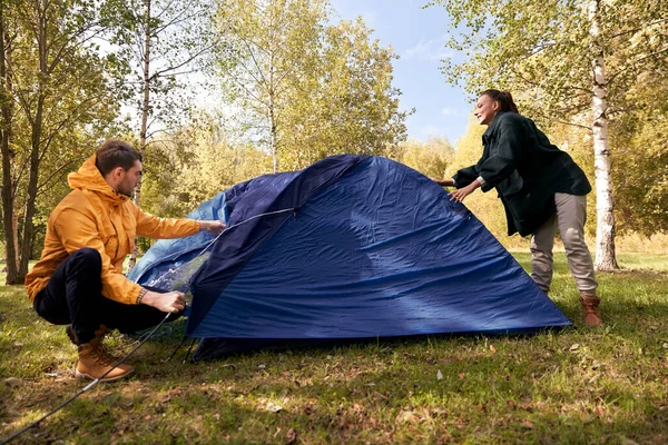 Couple heureux installant la tente à l'extérieur — Photo