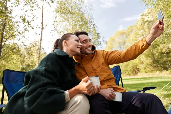 Couple drinking tea and taking selfie at camp — Stock Photo, Image
