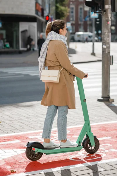 Şehirdeki bisiklet yolu boyunca scooter süren kadın. — Stok fotoğraf