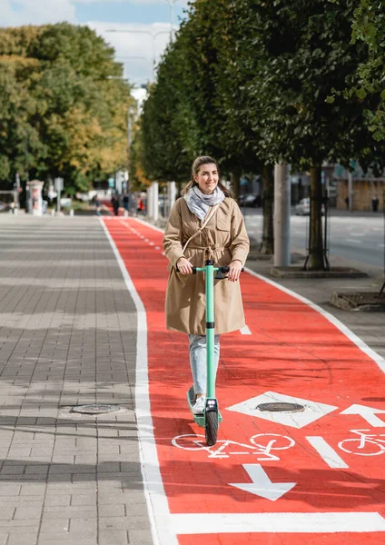 Γυναίκα ιππασία σκούτερ κατά μήκος του δρόμου λωρίδα ποδήλατο στην πόλη — Φωτογραφία Αρχείου