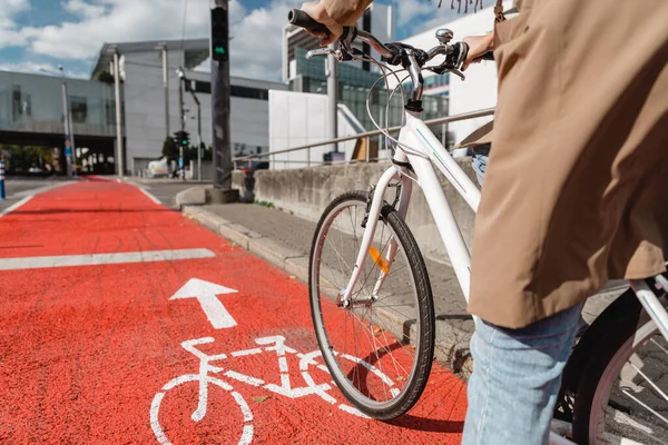 Жінка їде на велосипеді вздовж дороги червоного велосипеда в місті — стокове фото
