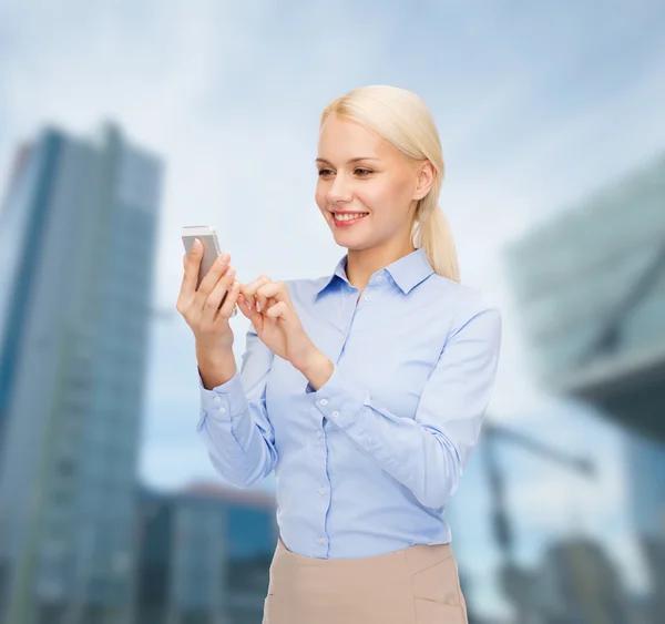 Jeune femme d'affaires souriante avec smartphone — Photo