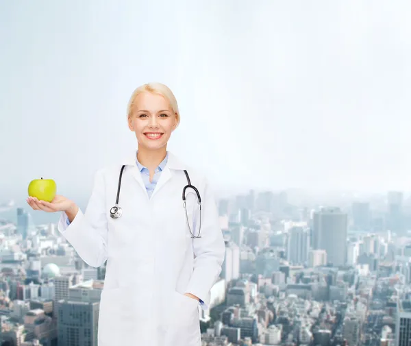 Femme médecin souriante avec pomme verte — Photo