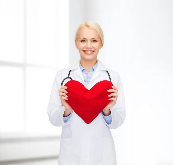 Doctora sonriente con corazón y estetoscopio —  Fotos de Stock