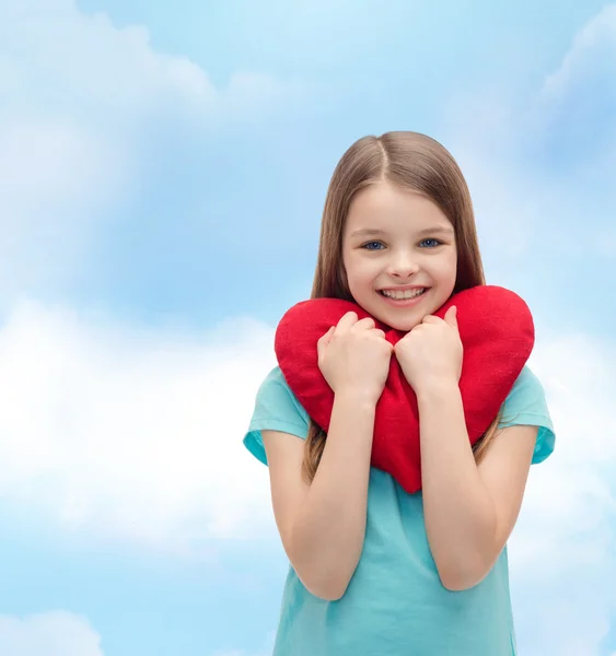 Smiling little girl with red heart — Stock Photo, Image