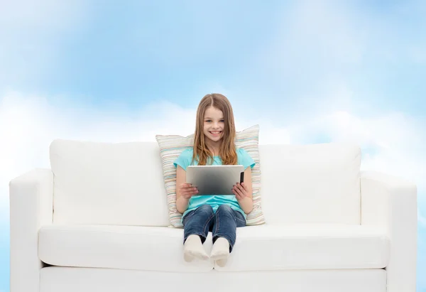 Niña sentada en el sofá con la tableta PC — Foto de Stock