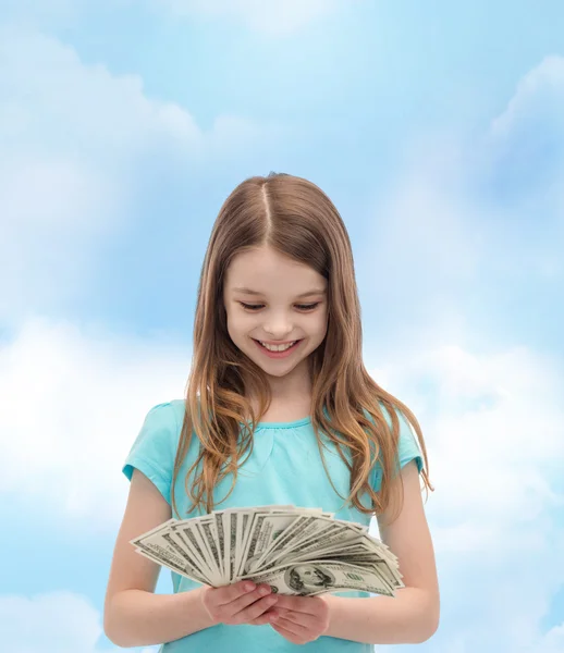 Sorrindo menina olhando para o dinheiro em dinheiro dólar — Fotografia de Stock