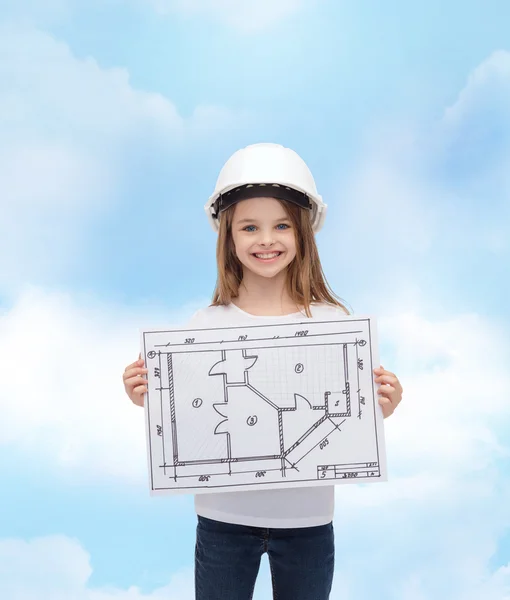 Smiling little girl in helmet showing blueprint — Stock Photo, Image