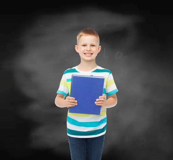 Sorrindo menino estudante com livro azul — Fotografia de Stock