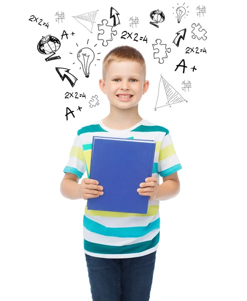 Sorridente piccolo studente ragazzo con libro blu — Foto Stock