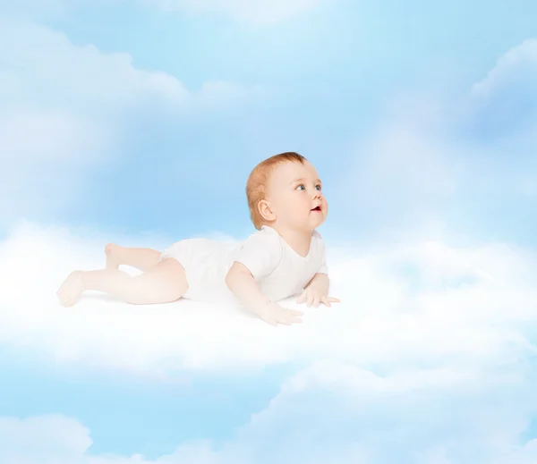 Sonriente bebé acostado en la nube y mirando hacia arriba — Foto de Stock