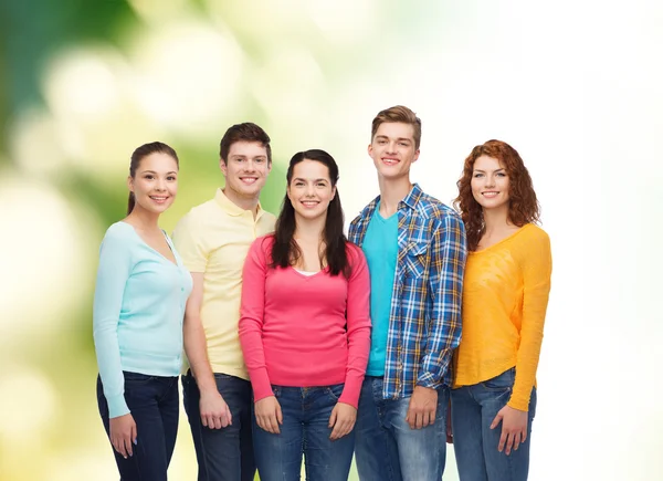 Grupo de adolescentes sonrientes sobre fondo verde — Foto de Stock