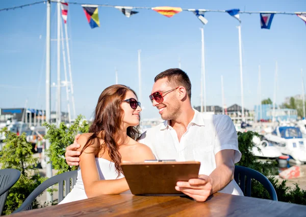 Smiling couple with menu at cafe — Stock Photo, Image