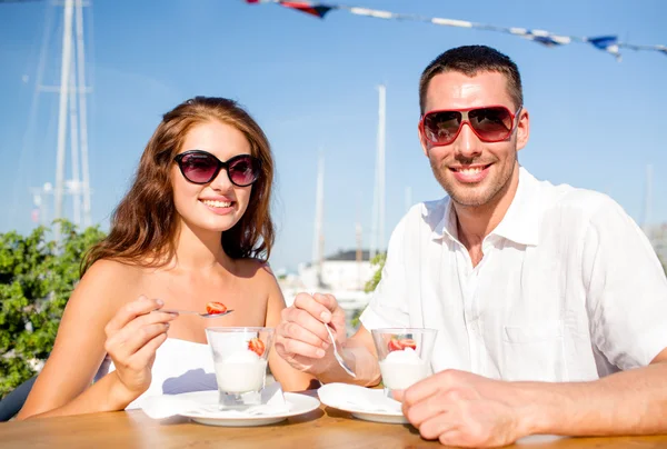 Smiling couple eating dessert at cafe — Stock Photo, Image
