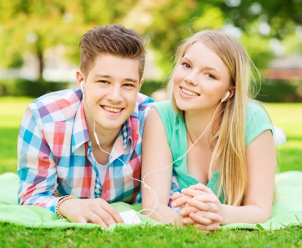 Coppia sorridente con smartphone e auricolari — Foto Stock