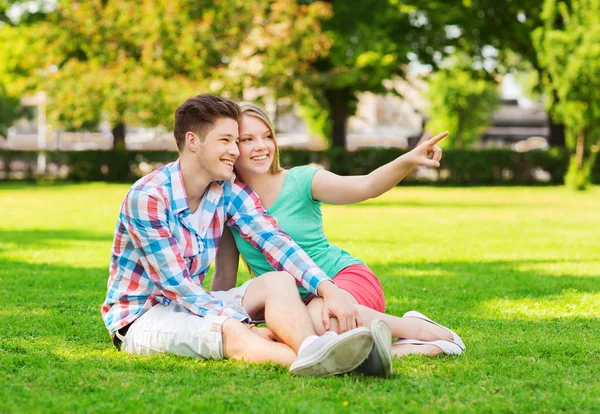 Усміхнена пара сидить на траві в парку — стокове фото