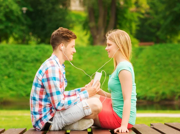 Couple souriant avec smartphone et écouteurs — Photo