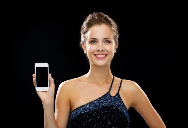 Lachende vrouw in avondjurk bedrijf smartphone — Stockfoto