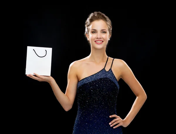 Mujer sonriente con bolsa blanca en blanco — Foto de Stock