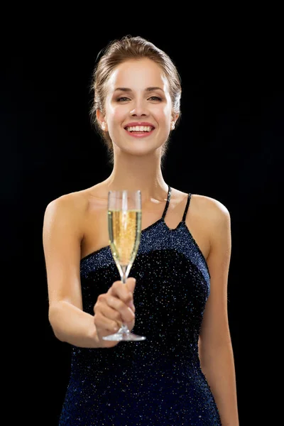 Sonriente mujer sosteniendo un vaso de vino espumoso —  Fotos de Stock