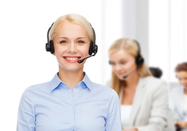 Friendly female helpline operator with headphones Royalty Free Stock Images